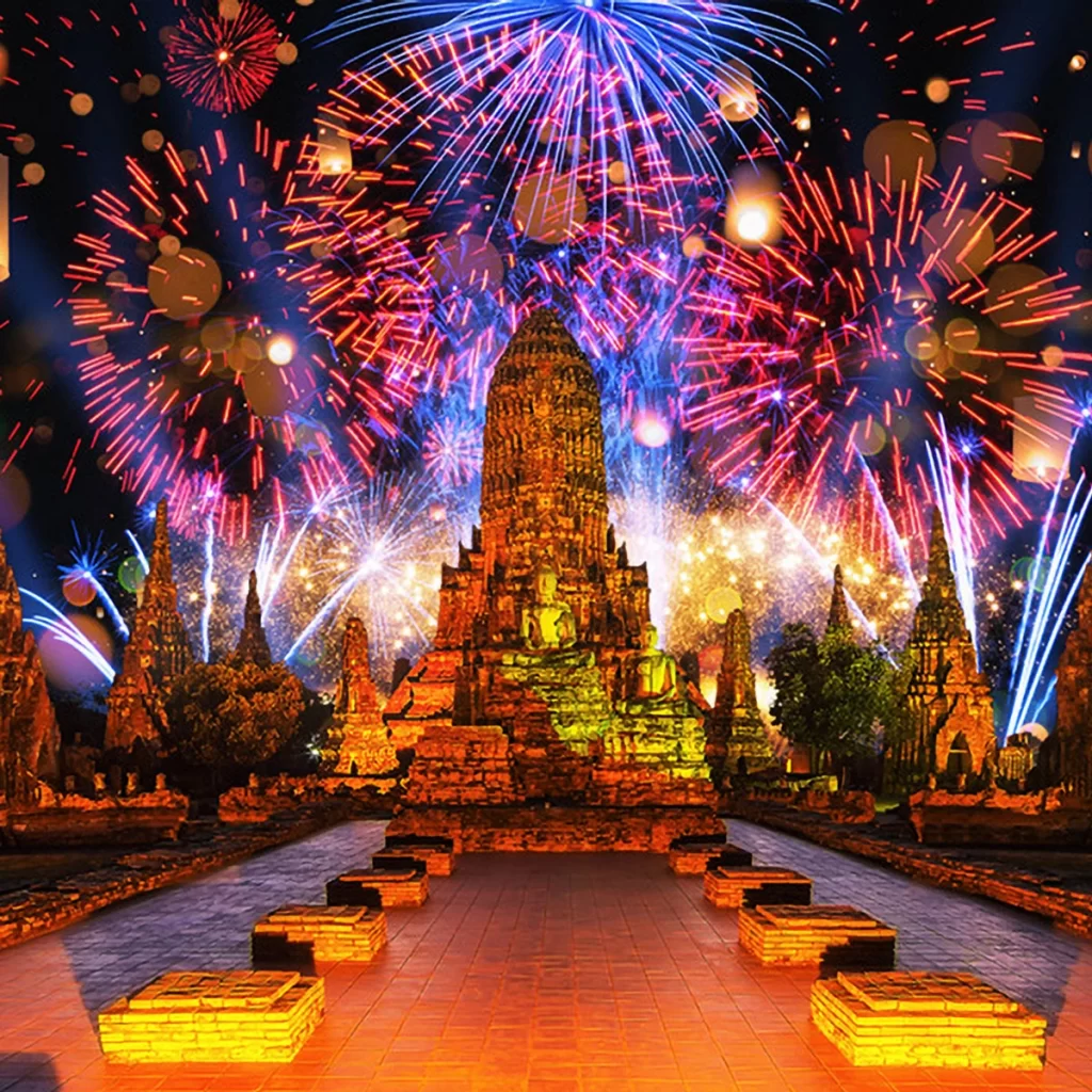 Vibrant fireworks illuminate the night sky above Ayutthaya Historical Park, with ancient temple ruins glowing in warm, golden light.