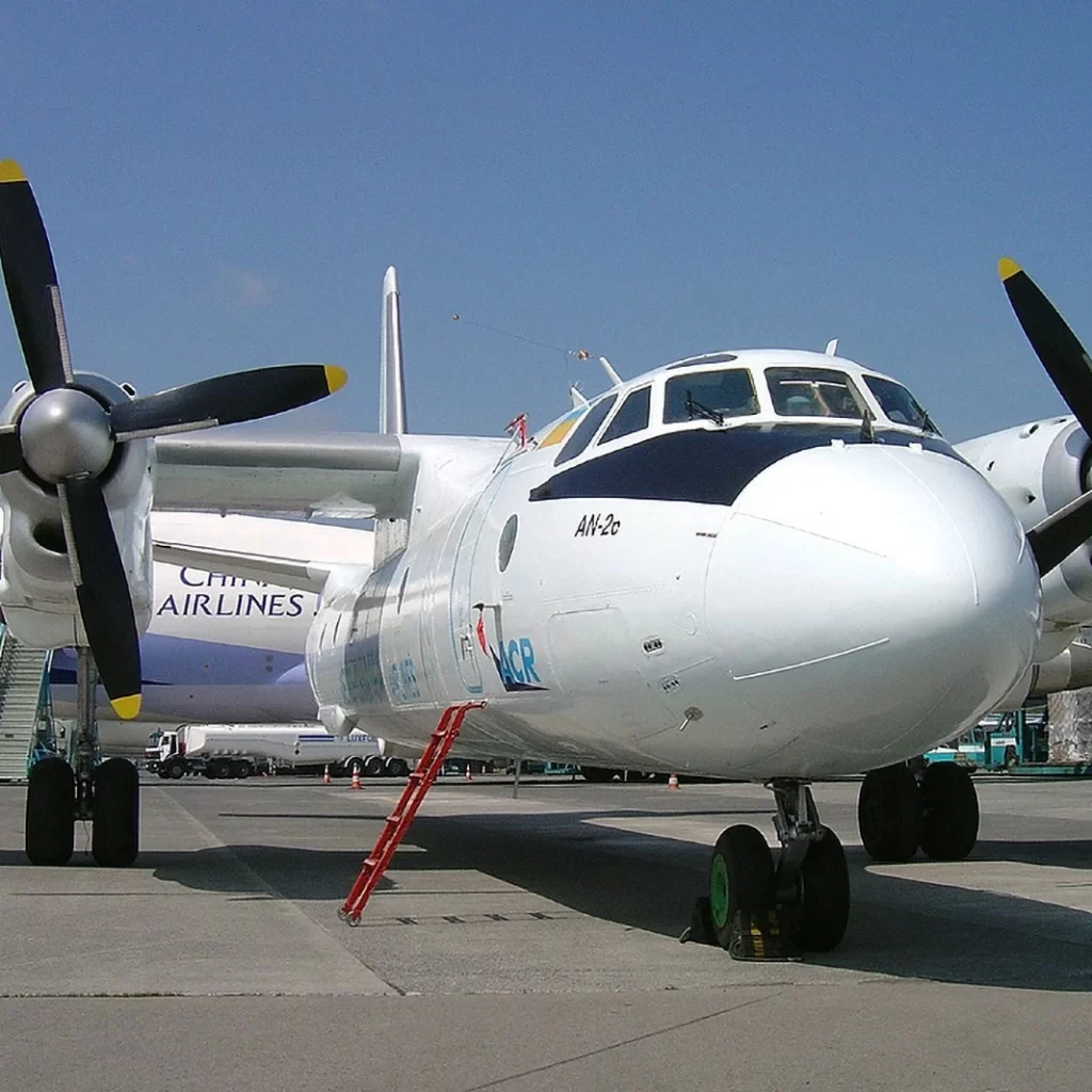 Front view of a white twin-engine propeller aircraft on the tarmac