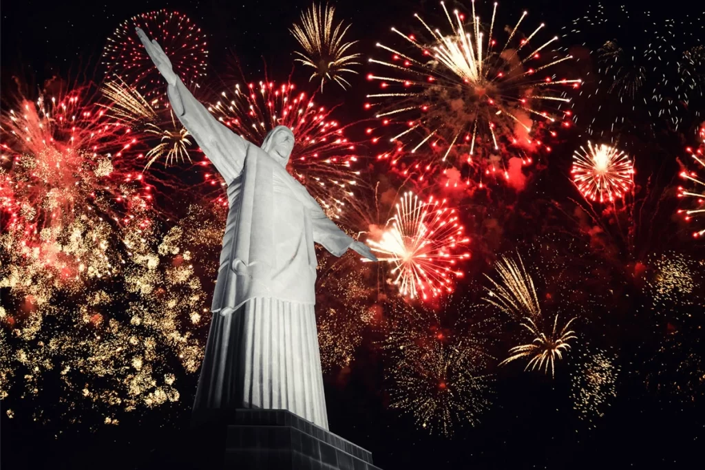 The Christ the Redeemer statue in Rio de Janeiro, Brazil, illuminated by a vibrant fireworks display during New Year’s Eve celebrations.