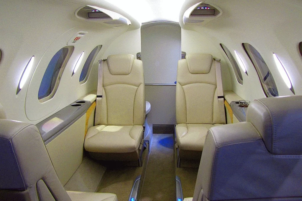 Interior view of a private jet cabin with luxurious leather seats and ample legroom.