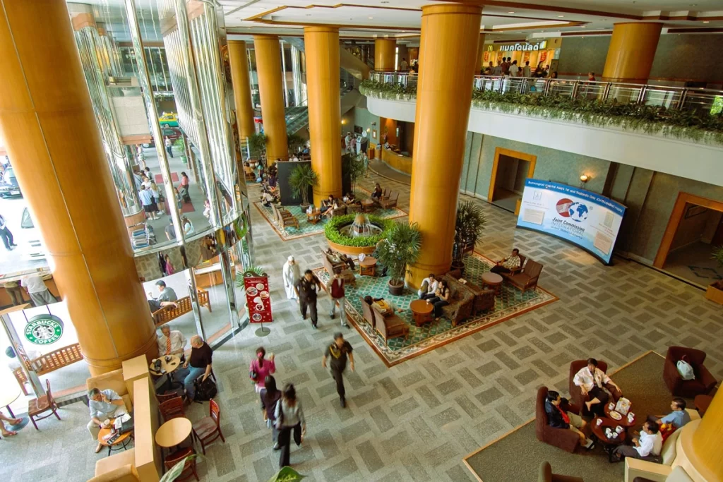 Modern and welcoming hospital lobby with natural light, seating areas, and international visitors enjoying the ambiance