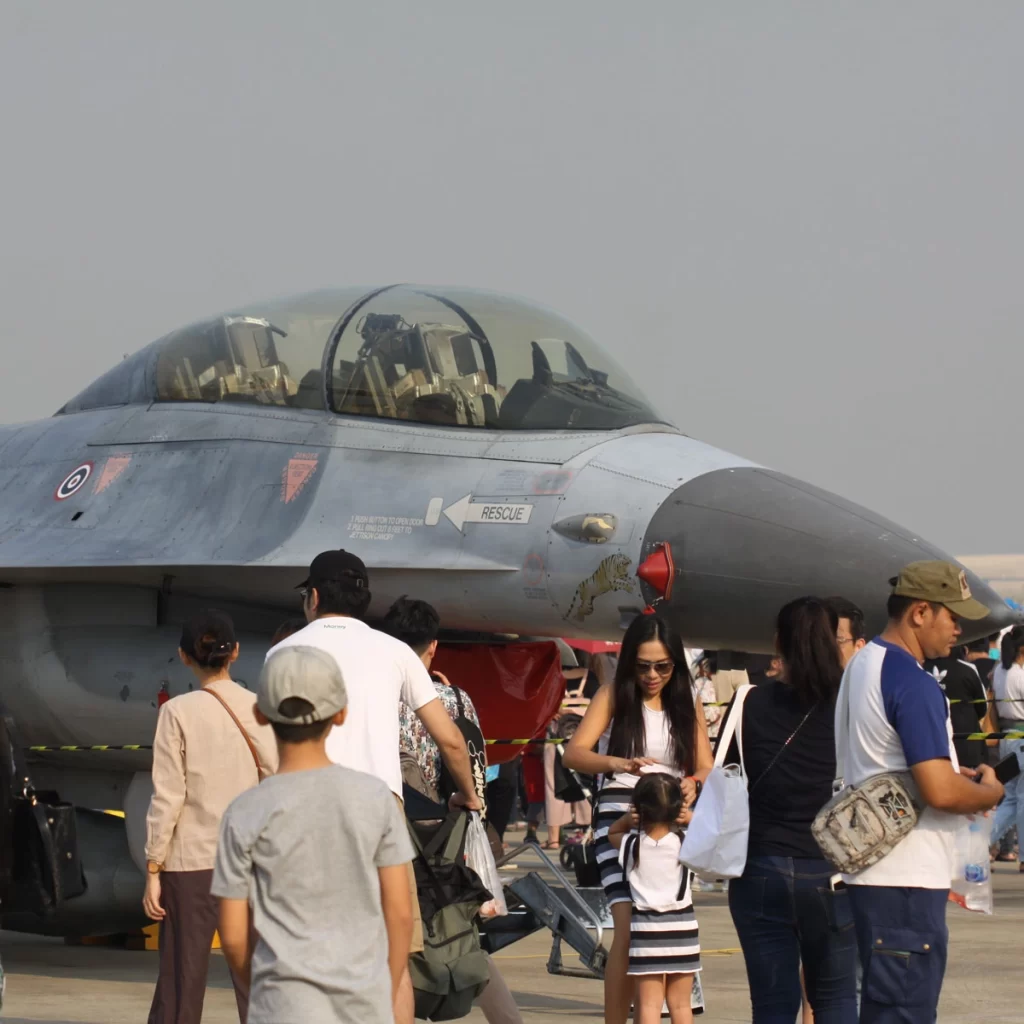 Children sitting in an aircraft cockpit with a pilot at Thung Si Kan Airfield