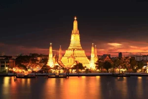 Wat Arun (Temple of Dawn), a riverside temple in Bangkok with colorful porcelain-adorned spires, offering stunning sunrise and sunset views.