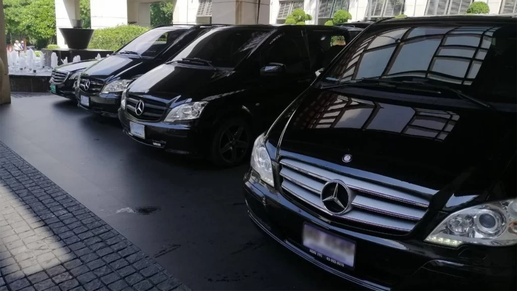 Luxury black Mercedes-Benz vans parked at a five-star hotel for Chauffeured Van Rental services in Thailand.