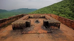 Ancient ruins atop a hill in Rajgir, India, overlooking lush green valleys