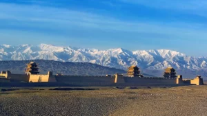 Ancient fortress in Hexi Corridor with snow-capped mountains in the background, part of the Silk Road route possibly traveled by Xuanzang